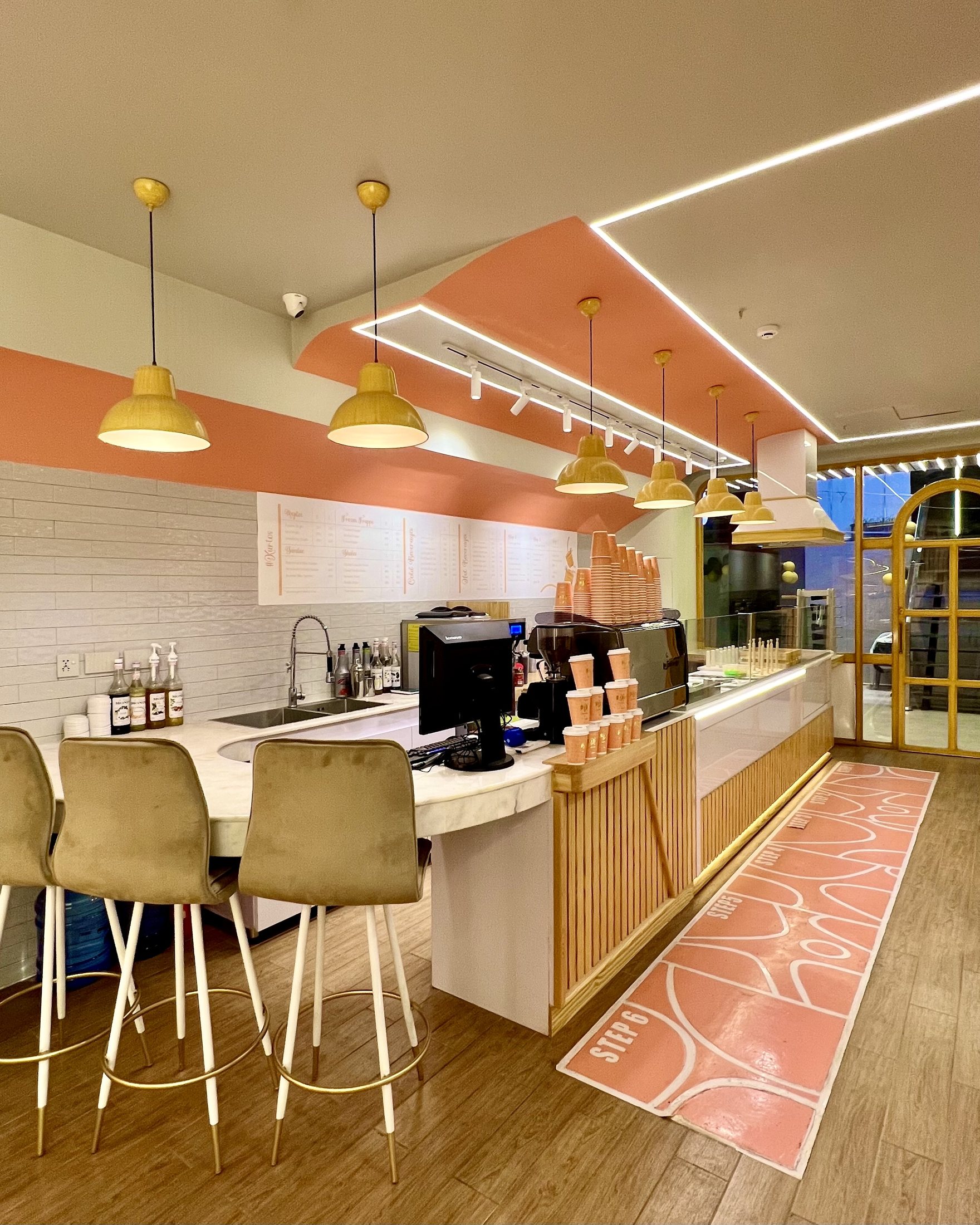 Completed Kurtos counter area with marble worktop, timber cladding, pendant lights, linear ceiling lighting and arched frontage.